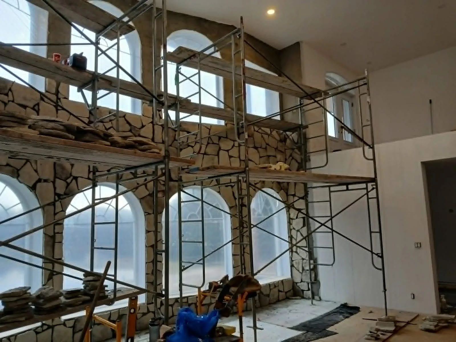 Travaux de maçonnerie réalisés sur échafaudage à l’intérieur